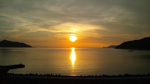 夕日で海面が、黄色く反射している写真